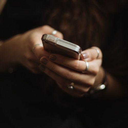 Fotografía ilustrativa de una persona utilizando un teléfono para revisar mensajes